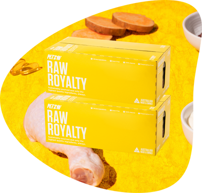 Two boxes of chick magnet, a Raw Dog Food by Petzyo with its ingredients in background